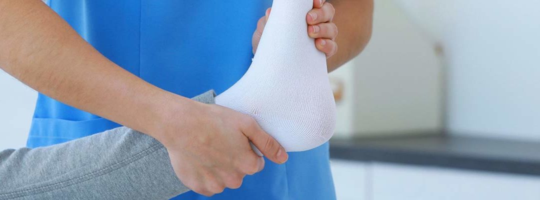nurse lifting a bandaged foot to prevent bed sores