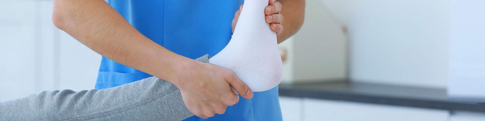 nurse lifting a bandaged foot to prevent bed sores